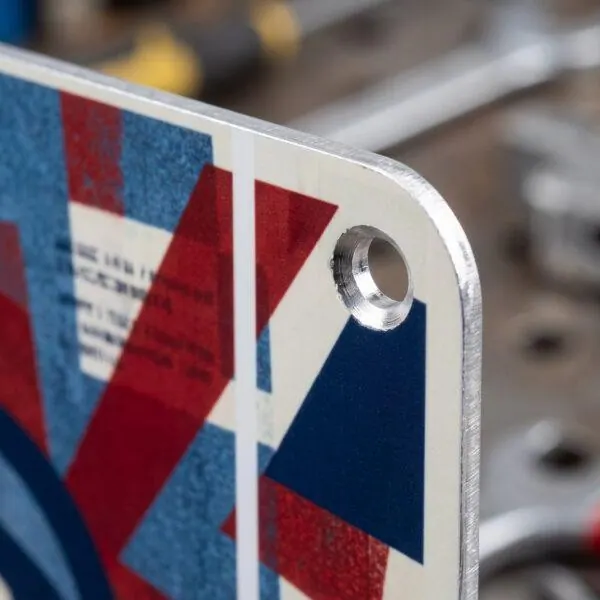 Close-up of rigid aluminum sign edge and mounting hole — Sign America Chicago