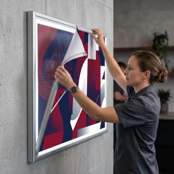 Poster being swapped in an LED light box snap frame — Sign America Chicago
