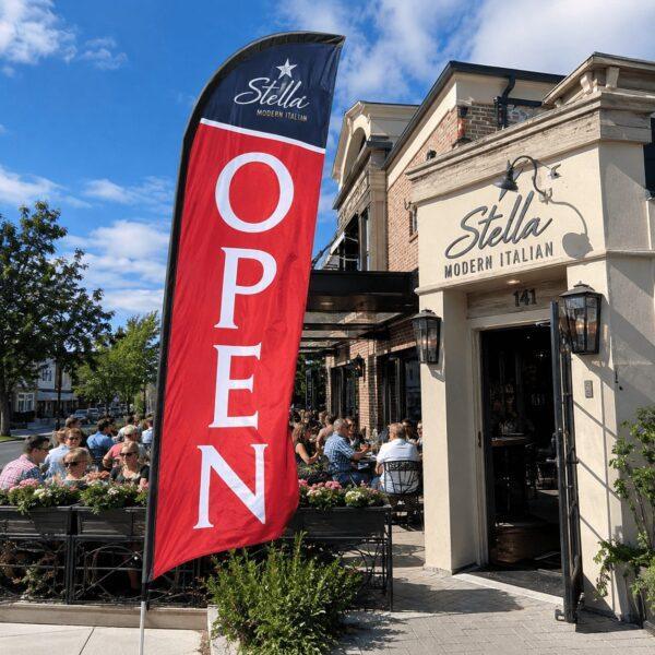 Feather flag flying outside a busy restaurant patio — custom feather flags Sign America Chicago