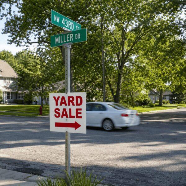 Setting up a yard sale sign on the front lawn — Sign America Chicago